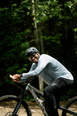 Man on a mountain bike holding Sunii Energy Gum, highlighting energy boost for outdoor adventures